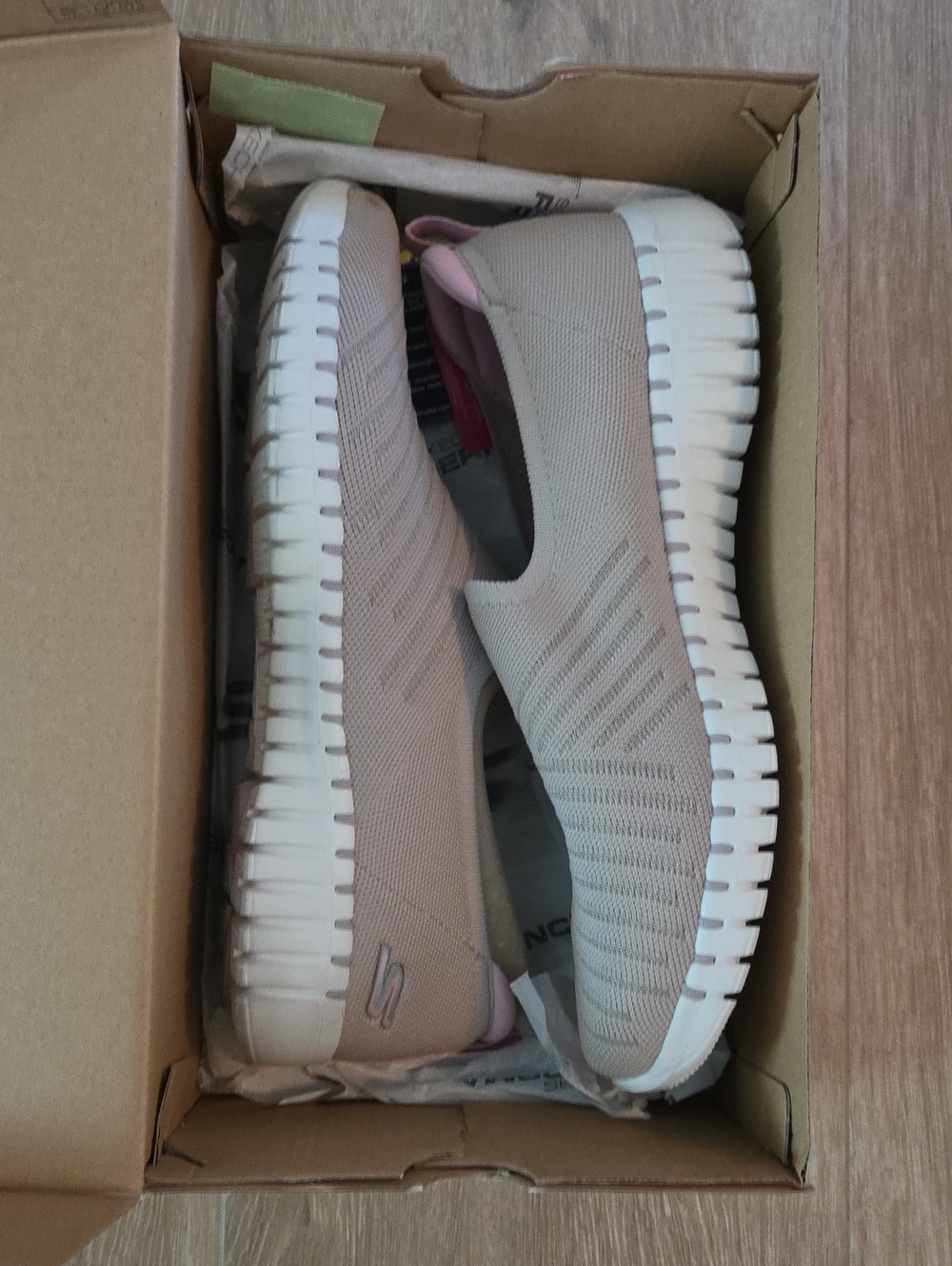 Skechers Women’s Beige Knit Slip-On Sneakers with White Sole and Pink Accents.
